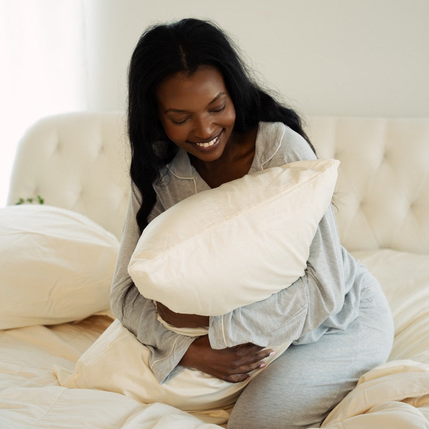 Organic pillow lifestyle — woman with OrganicTech Dual Sided Pillow, Talalay latex core, toxin-free organic cotton